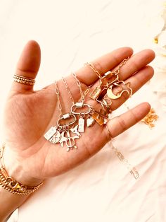 a person's hand holding several different pieces of jewelry