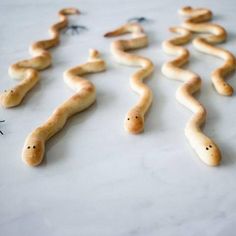 some very cute looking food items on a white counter top with one worm in the middle