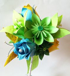 a vase filled with paper flowers on top of a table