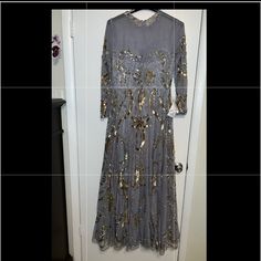 a dress is hanging on a door and it has gold sequins all over it