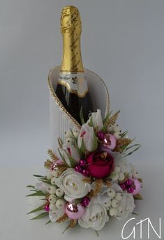 a bottle of champagne and some flowers on a white tablecloth with gold trimmings