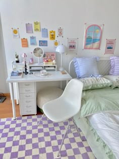 a bedroom with a bed, desk and chair next to a wall covered in pictures