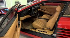 the interior of a red sports car in a showroom