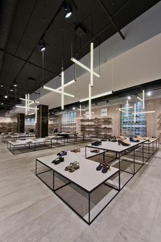 a room filled with lots of white tables and shoes on top of each other in front of windows