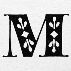 the letter m is made up of black and white letters with leaves on them,