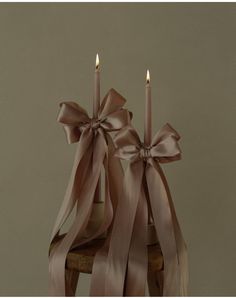 two candles with ribbons tied around them