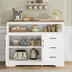 a kitchen with white cupboards and shelves filled with dishes, coffee mugs and other items