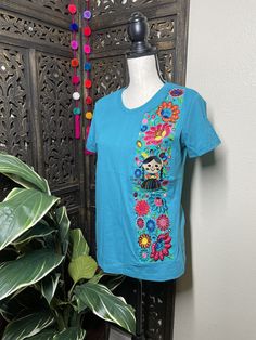 This is a light weight and fresh looking beautiful soft and solid embroidered blouse. It will look great with jeans. The embroidered work is beautiful and delicate. The design has a precious thread embroidered floral pattern. All the work is clean, and with a professional look. You will Love it! Blouse STYLE DETAILS Overview * embroidered flowers * short sleeves fabric & care * hand wash only * delicate care * hang dry If you have any questions, please message me before buying. See you soon. Spring Cotton Embroidered Top With Machine Embroidery, Cotton T-shirt With Embroidery For Spring, Blue Tops With Embroidered Text For Spring, Bohemian Embroidered Summer T-shirt, Embroidered Crew Neck Blouse, Blue Embroidered Relaxed Fit T-shirt, Multicolor Floral Embroidery T-shirt For Summer, Traditional Embroidered Cotton T-shirt, Crew Neck Blouse With Floral Embroidery