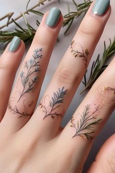 a woman's hand with tattoos on her fingers and the ring is decorated with flowers