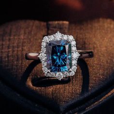 a fancy ring with a blue diamond surrounded by diamonds