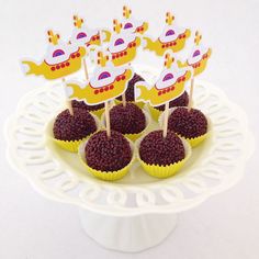 there are cupcakes that have been placed on a cake plate with some decorations