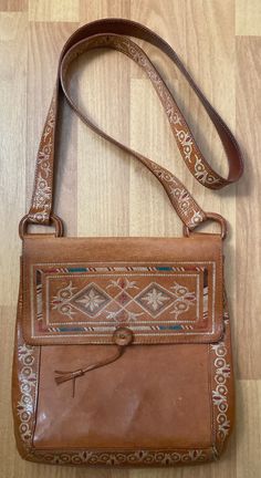 "Brown Tooled Floral Colorful Leather Shoulder Crossbody Bag Purse  Snap Closure, One interior pocket Condition is Used The exterior has some scuffs. The interior is in very good condition. Please use your zoom in option to view all the details. Length 10\" x Width 2\" x Height 10\" Strap drop 22\" Pictures don't do it justice. This is one beautiful handcrafted tooled leather bag." Vintage Brown Shoulder Bag With Cell Phone Pocket, Retro Hand Tooled Shoulder Bag For Travel, Retro Hand-tooled Bags, Multicolor Hand Tooled Travel Bags, Vintage Satchel Shoulder Bag With Cell Phone Pocket, Hand Tooled Crossbody Satchel For Travel, Hand Tooled Leather Shoulder Bag For Travel, Vintage Rectangular Satchel With Cell Phone Pocket, Traditional Shoulder Bag With Cell Phone Pocket For Travel