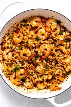 a pan filled with shrimp and rice on top of a table