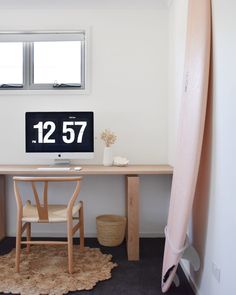 a desk with a surfboard next to it and a clock on the wall above it