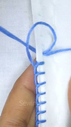 someone is stitching something with blue thread