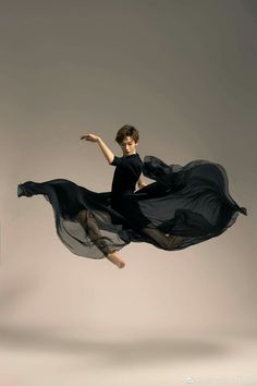 a woman in black dress flying through the air