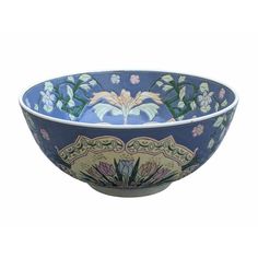 a blue and white bowl with flowers on the side, sitting in front of a white background