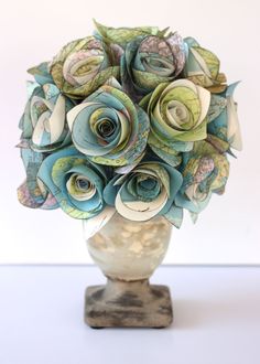 a vase filled with paper flowers on top of a table