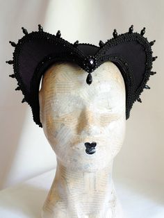 This is a purple and black version of one of most successful designs called Countess. This vampire style headdress is covered with dark purple taffeta and embellished with black cord trimming all around the edges.It is further trimmed with black crystal details that create a halo effect as well as small l beads that were hand-sewn on the trimming to create rich textural interest. The piece is completed with a black crystal handmade element placed at the center front for all that extra drama that Fitted Black Gothic Costume, Black Fitted Gothic Costume, Gothic Costume Accessories For Masquerade And Cosplay Events, Handmade Black Headpiece For Costume, Black Fitted Costumes For Alternative Fashion, Fitted Black Costume For Alternative Fashion, Elegant Halloween Theater Costumes, Black Fitted Costume For Alternative Fashion, Fitted Black Costume Accessories For Cosplay Events