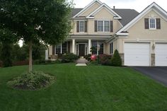 a large house with two garages in the front yard