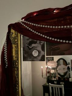 a mirror with pearls hanging on it next to a table