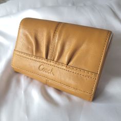 Coach Soho Saffron Pleated Leather Coach Monogram Pattern Bi-Fold Clutch Wallet Nwt This Bi-Fold Is The Perfect Wallet For A Smaller Crossbody Or Shoulder Bag. It's Fall Ready. Features: *Several Slip Pockets Inside And Out For Ids & Credit Cards. *Main Zipper Compartment To Add More Cards Or Cash. *Side Cash Compartment *Unique Front Pleat *Genuine Leather With The Coach Monogram Pattern *Clutch Style With Quality Outer Seam Detail Style Tags: Functional, Everyday, Compact, Soho, High Quality, Durable. Measures: 5.5"W X 3.5" H X 1"Thick This Item Is Nwt. With A Price Tag Of $188.00, This Price Is A Great Deal! Full Disclosure: It Does Have A Few Marks From Being Stored That S Coach Gold Leather Wallet, Gold Leather Bifold Bag, Gold Bifold Leather Bag, Coach Monogram, Full Disclosure, Monogram Pattern, Leather Coach, Small Crossbody, It's Fall