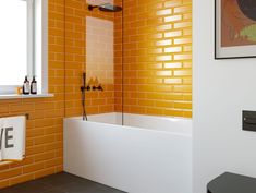 a bathroom with yellow brick walls and white bathtub next to a black counter top