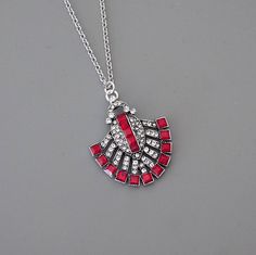 "Vintage Jewelry - Art Deco Inspired Necklace - Ruby Red Necklace - Crystal Necklace - Silver Necklace - Chloe's Vintage JewelryHandmade This is such a gorgeous Art Deco inspired necklace!  A stunning design embellished with sparkling red and clear crystals.  The pendant hangs from a silver plated chain.   Chloe says, \"Wear it and feel fabulous!\" The pendant measures 1 1/2\" long.  You can choose the length you would like at checkout. Thanks for visiting Chloe's" Red Pendant Necklace Costume Jewelry, Red Pendant Costume Jewelry Necklace, Red Pendant Necklace In Costume Jewelry Style, Red Pendant Necklace With Lobster Clasp, Red Pendant Necklaces For Party, Vintage Red Necklace With Lobster Clasp, Vintage Red Jewelry With Adjustable Chain, Ruby Red Necklace, Birthday Presents For Friends