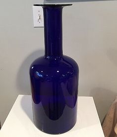 a blue vase sitting on top of a white table