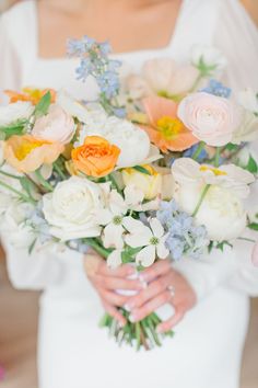 a woman holding a bouquet of flowers in her hands