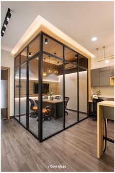 an office with glass walls and wooden flooring is seen in this image from the inside