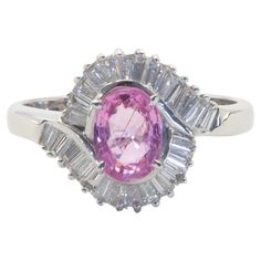 This quality and beautiful engagement piece is an 18K white gold fine quality pink sapphire and diamond ring. A bubblegum oval pink sapphire is set meticulously. The sapphire has lines of inclusion running across the face, other than that- very clear and bright gemstone. There are numerous of tapered baguette cut diamonds at decent size and of good bling quality. A cocktail engagement ring gift to people who are born in September and for those who pink colored gemstones! Elegantly designed for w Born In September, Baguette Diamond Ring, Round Diamond Earrings, Colored Gemstones, Baguette Diamond Rings, Sapphire And Diamond Ring, Gold Cocktail Ring, Gold Cocktail, Diamond Cocktail Rings