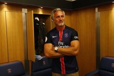 a man standing in a dressing room with his arms crossed