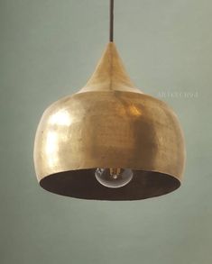 a gold colored light hanging from a ceiling