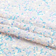 white and blue sequinized fabric with lots of small dots on it's surface