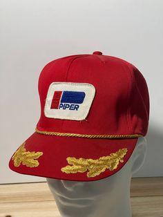 Vintage 1970's Original Piper Airplane Trucker Hat Snap Back Patch Logo all Cotton Red This is a real Vintage Piper Airplane hat from the 1970's, it's in pristine condition.   The patch and hat are all Original. These hats are getting super hard to find and are over 50 Years old !  See photos to determine condition yourself Made in the USA by popular high quality brand AtHats! 100% Cotton hat 6-panel cap Seamed Front Panel with Patch No Stitching on the Visor Matching Fabric Under visor Adjustab Retro Trucker Hat With Logo Patch And Curved Bill, Retro Red Snapback Trucker Hat, Piper Cub, Vintage 5-panel Trucker Hat, Vintage 5-panel Hat With Logo Patch, Vintage 5-panel Trucker Hat With Logo Patch, Vintage Trucker Hats, Mesh Hat, Bad To The Bone