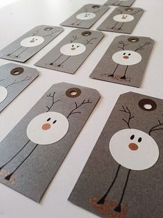 several tags with snowmen on them sitting on top of a white table next to each other