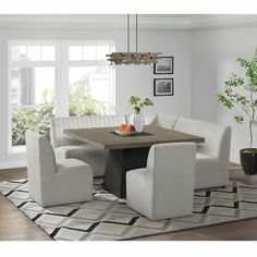 a dining room table with four chairs and a potted plant in the corner on top of it