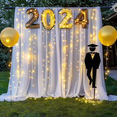 a graduation backdrop with balloons and lights