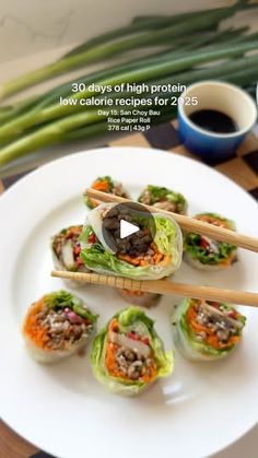 a white plate topped with sushi and chopsticks