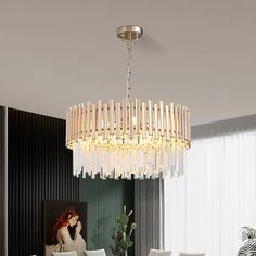 a modern chandelier hanging from the ceiling in a dining room with white chairs