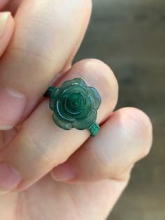 a person holding a green ring with a flower on it