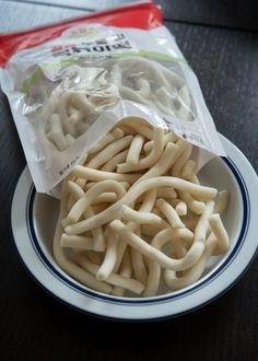 a bag of noodles sitting on top of a white and blue plate