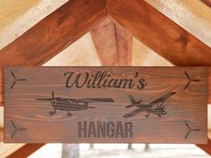 a wooden sign hanging from the side of a building that says, william's hangar