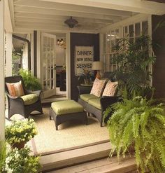 the front porch is decorated with plants and furniture