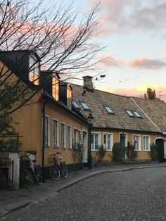 a cobblestone street lined with houses and bicycles