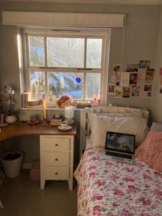 a laptop computer sitting on top of a desk next to a bed in a bedroom