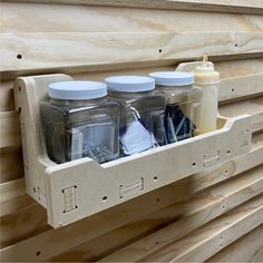 three jars are sitting on a shelf with screws