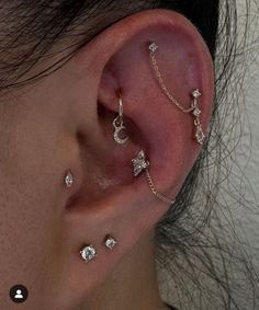 a woman's ear with three different piercings