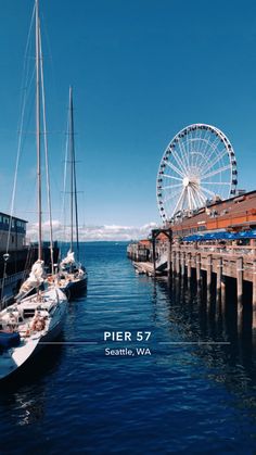 there are many boats that are docked at the pier with ferris wheel in the background